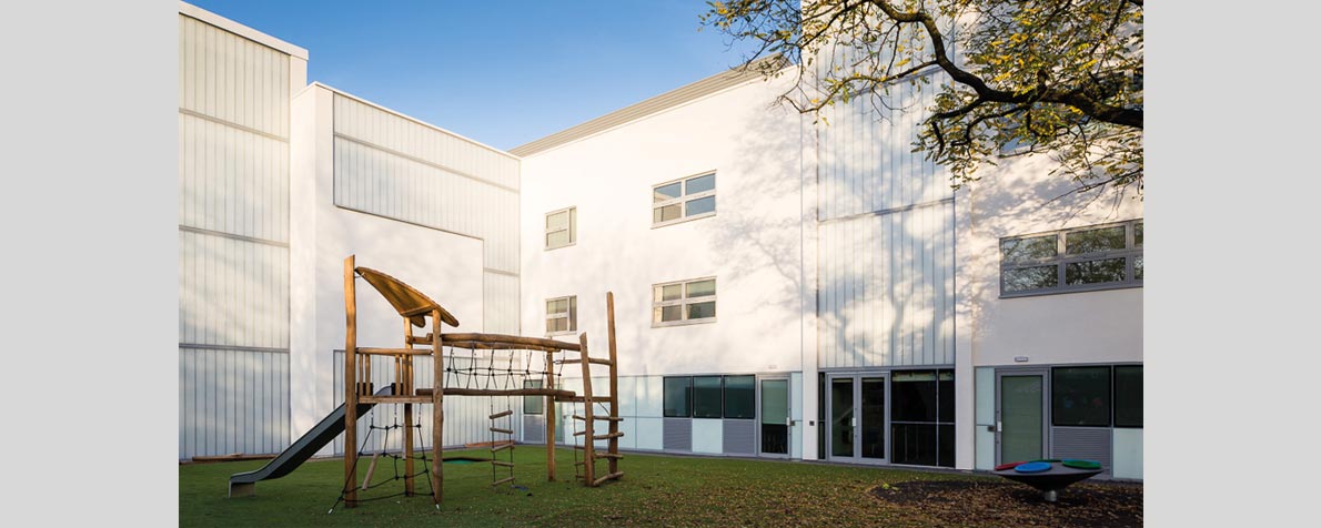 Wall panels clad in white render and translucent glazing at Queensmill ASD School