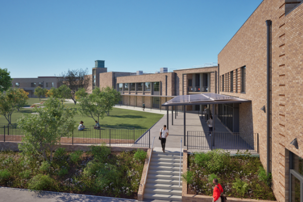 A modern school campus featuring brick buildings and a neatly maintained green lawn. Trees are scattered throughout the area, with a few people walking or sitting. A staircase leads to a covered walkway connecting two buildings. The sky is clear and blue, suggesting a sunny day.
